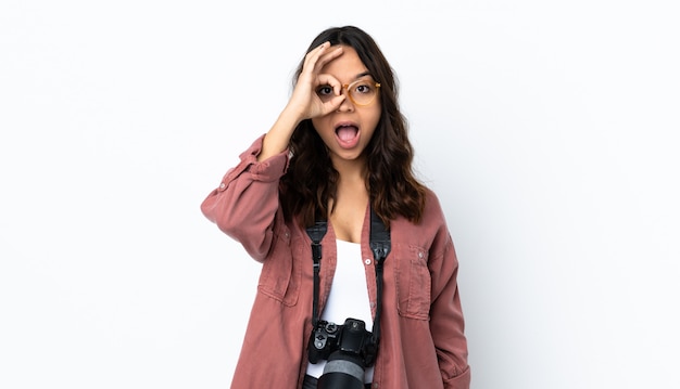 Mujer joven fotógrafo sobre blanco aislado mostrando signo bien con los dedos