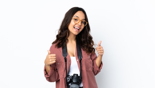 Mujer joven fotógrafo sobre fondo blanco aislado dando un gesto de pulgares arriba