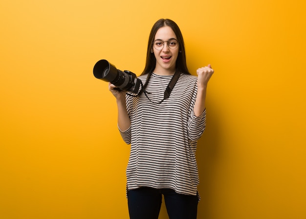 Mujer joven fotógrafo sorprendida y conmocionada