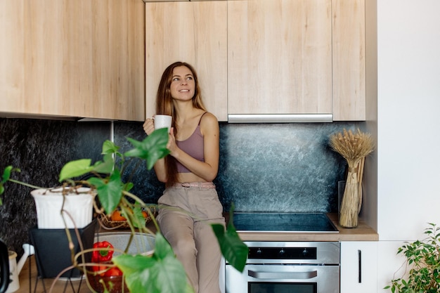 Mujer joven con frutas en la cocina Comida vegana saludable en casa