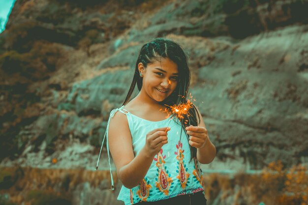 Foto mujer joven con fuegos artificiales