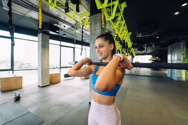 Foto mujer joven fuerte haciendo sentadillas con una barra