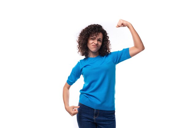 Foto mujer joven y fuerte con un suéter azul y cabello rizado