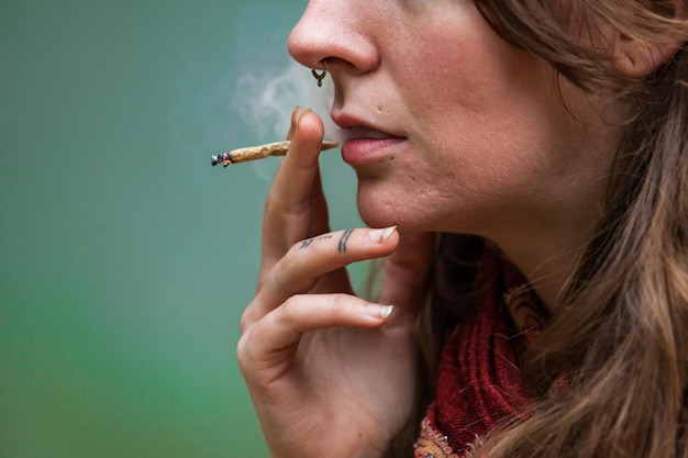 Foto mujer joven fumando un cigarrillo