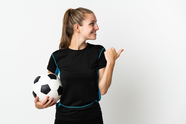 Mujer joven futbolista aislada en blanco apuntando hacia el lado para presentar un producto