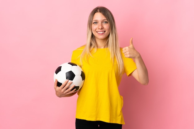 Mujer joven futbolista aislada en la pared rosada dando un pulgar hacia arriba gesto