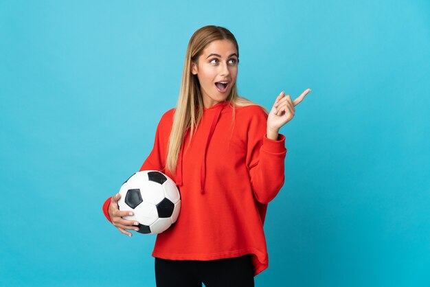 Mujer joven futbolista en azul con la intención de darse cuenta de la solución mientras levanta un dedo