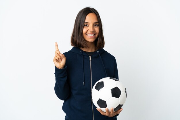 Mujer joven futbolista en blanco mostrando y levantando un dedo en señal de lo mejor