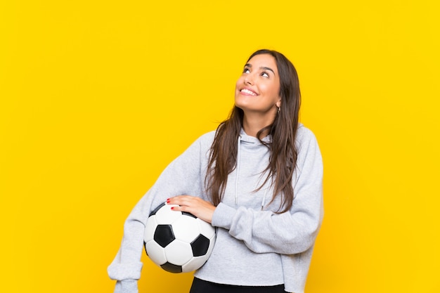 Mujer joven del futbolista que mira para arriba mientras que sonríe