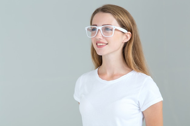 Mujer joven con gafas aislados en gris