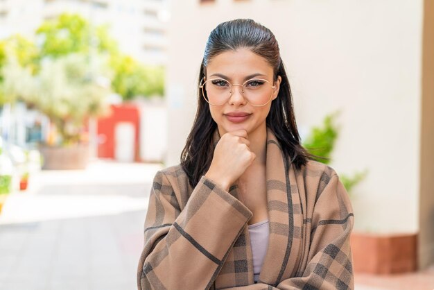 Foto mujer joven con gafas al aire libre pensando