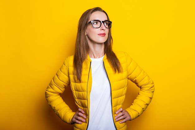 Foto mujer joven con gafas y chaqueta amarilla