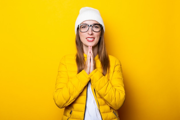 Mujer joven con gafas y chaqueta amarilla