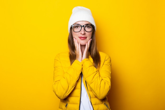 Mujer joven con gafas y chaqueta amarilla