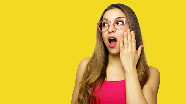 Foto mujer joven con gafas contra un fondo amarillo