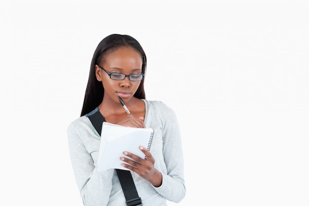 Mujer joven con gafas leyendo sus notas