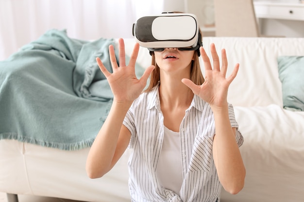 Mujer joven con gafas de realidad virtual en casa