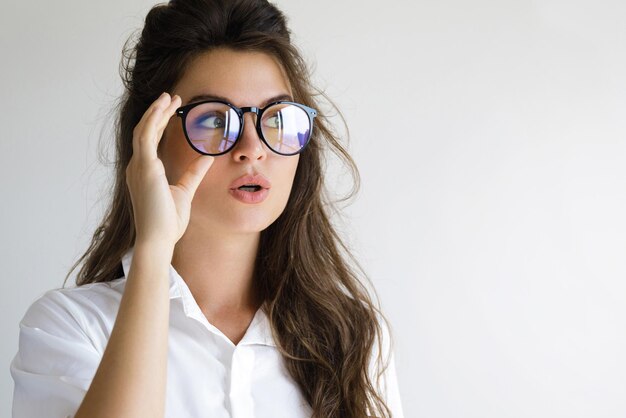 Foto mujer joven con gafas de sol contra un fondo blanco