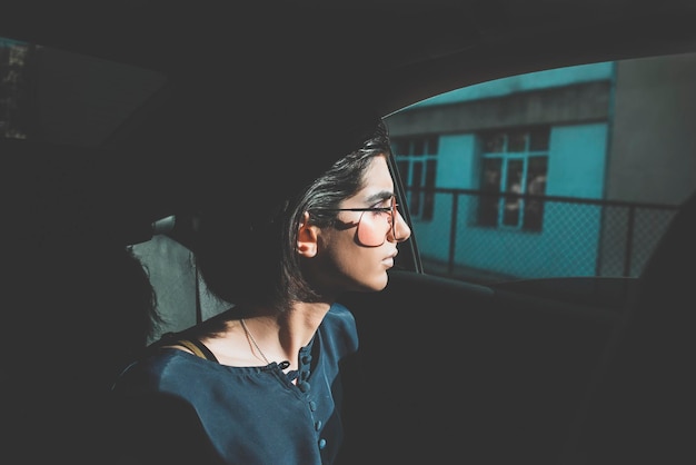 Foto mujer joven con gafas de sol mientras está sentada en el coche