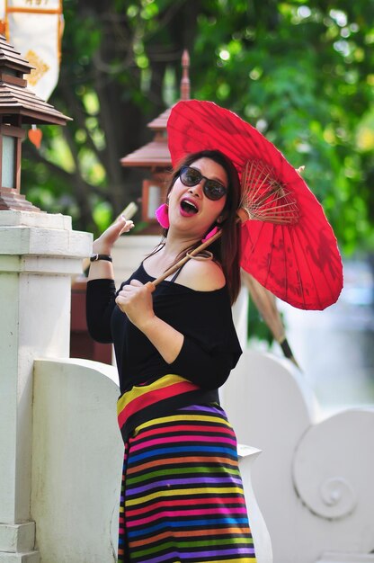 Mujer joven con gafas de sol de pie al aire libre