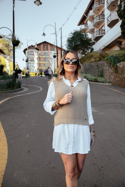 Mujer joven con gafas de sol de pie en la calle de la ciudad