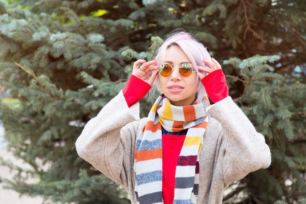 Mujer joven en gafas de sol sobre un fondo de abeto