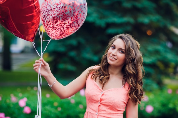 Mujer joven con globos en el parque