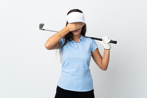 Mujer joven golfista sobre fondo blanco aislado que cubre los ojos con las manos. No quiero ver algo