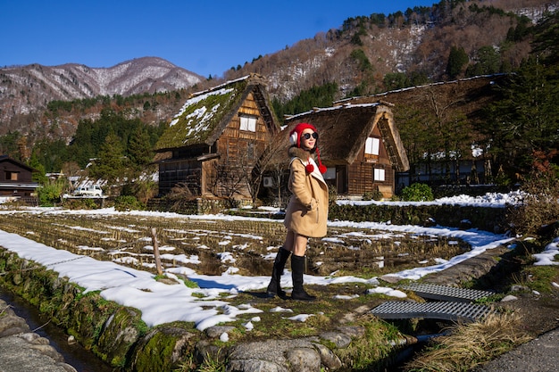 Mujer joven en una gorra roja con el fondo de granja de madera de patrimonio.