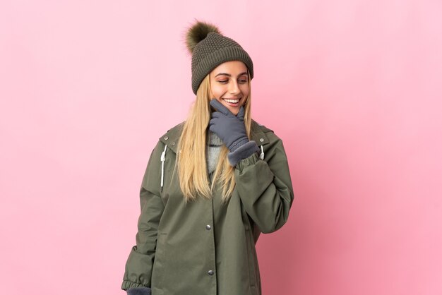 Mujer joven con gorro de invierno en rosa mirando hacia un lado y sonriendo