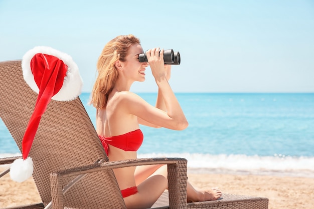 Mujer joven, con, gorro de santa, en, playa