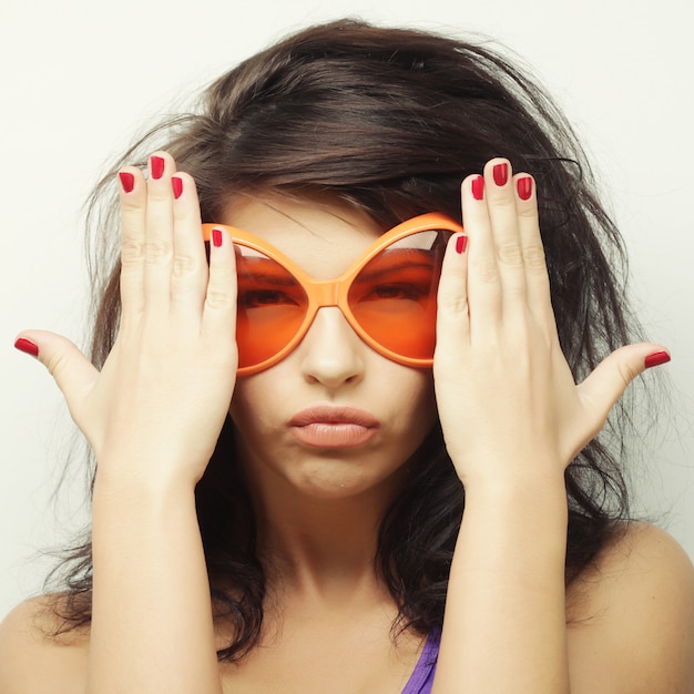 Mujer joven con grandes gafas de sol naranjas