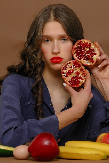 Mujer joven en grupo de frutas. Concepto de salud y nutrición saludable.