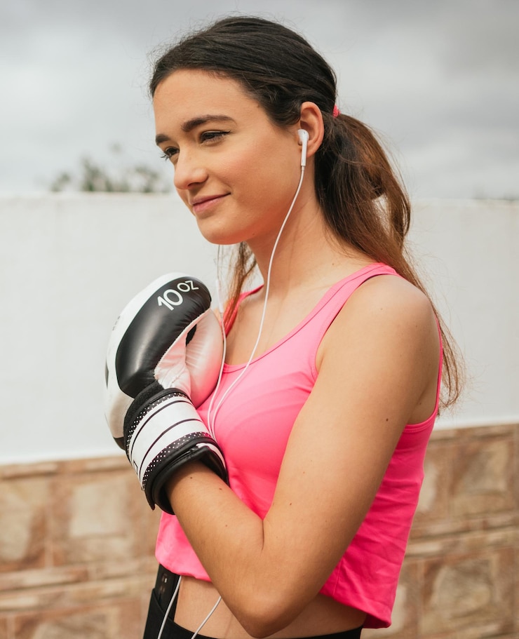 Foto mujer joven con guantes de boxeo