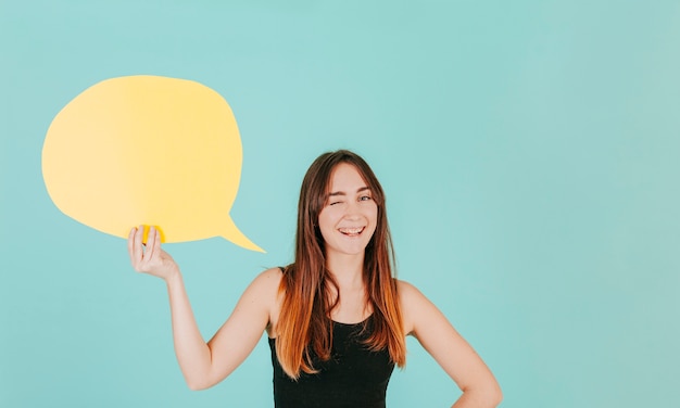 Mujer joven con guiño de burbuja de discurso