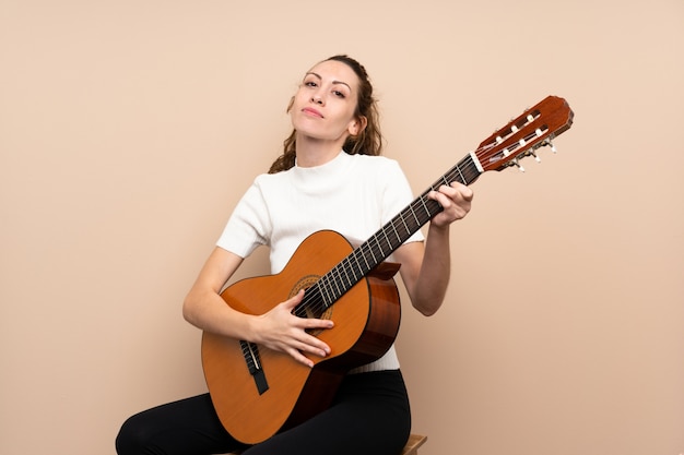 Mujer joven con guitarra sobre aislado