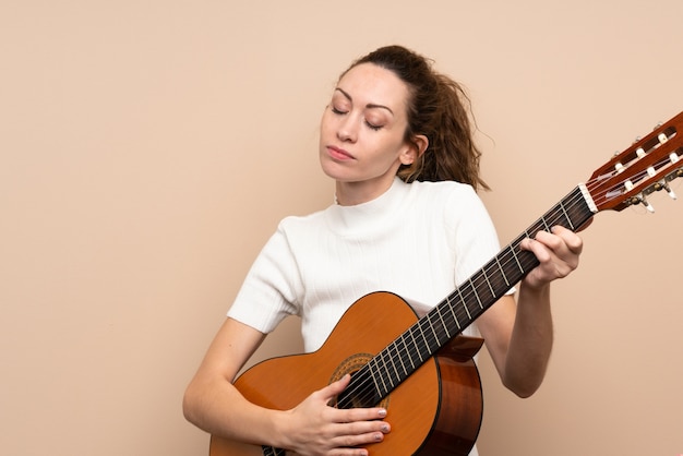 Mujer joven con guitarra sobre aislado