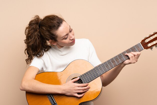 Mujer joven con guitarra sobre fondo aislado