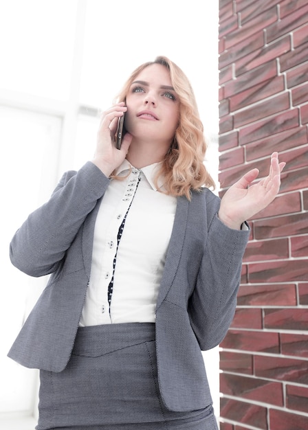 Mujer joven hablando en la foto del teléfono inteligente con espacio de copia