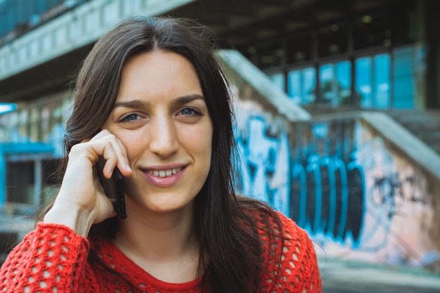 Mujer joven hablando por su teléfono móvil.