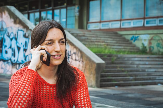 Mujer joven hablando por su teléfono móvil.