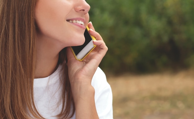 Foto mujer joven hablando por teléfono inteligente