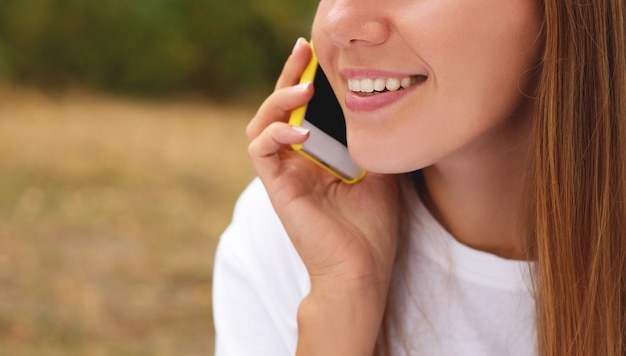 Mujer joven hablando por teléfono inteligente