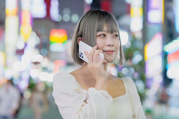 Mujer joven hablando por teléfono inteligente