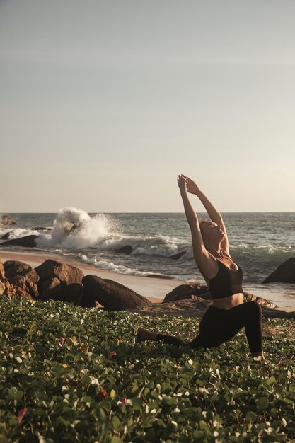 Mujer joven hace yoga para un estilo de vida saludable en la playa del mar