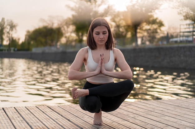 Foto mujer joven, hacer, yoga, en el lago