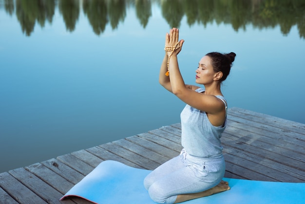 mujer joven, hacer, yoga, en el lago