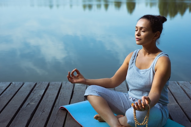 Foto mujer joven, hacer, yoga, en el lago