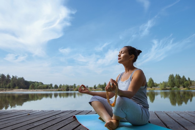 Foto mujer joven, hacer, yoga, en el lago