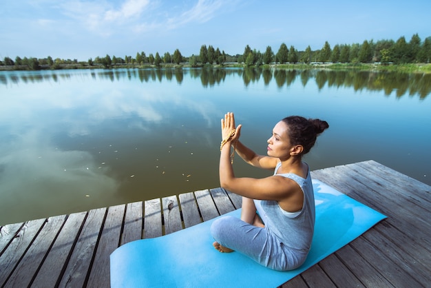 Foto mujer joven, hacer, yoga, en el lago